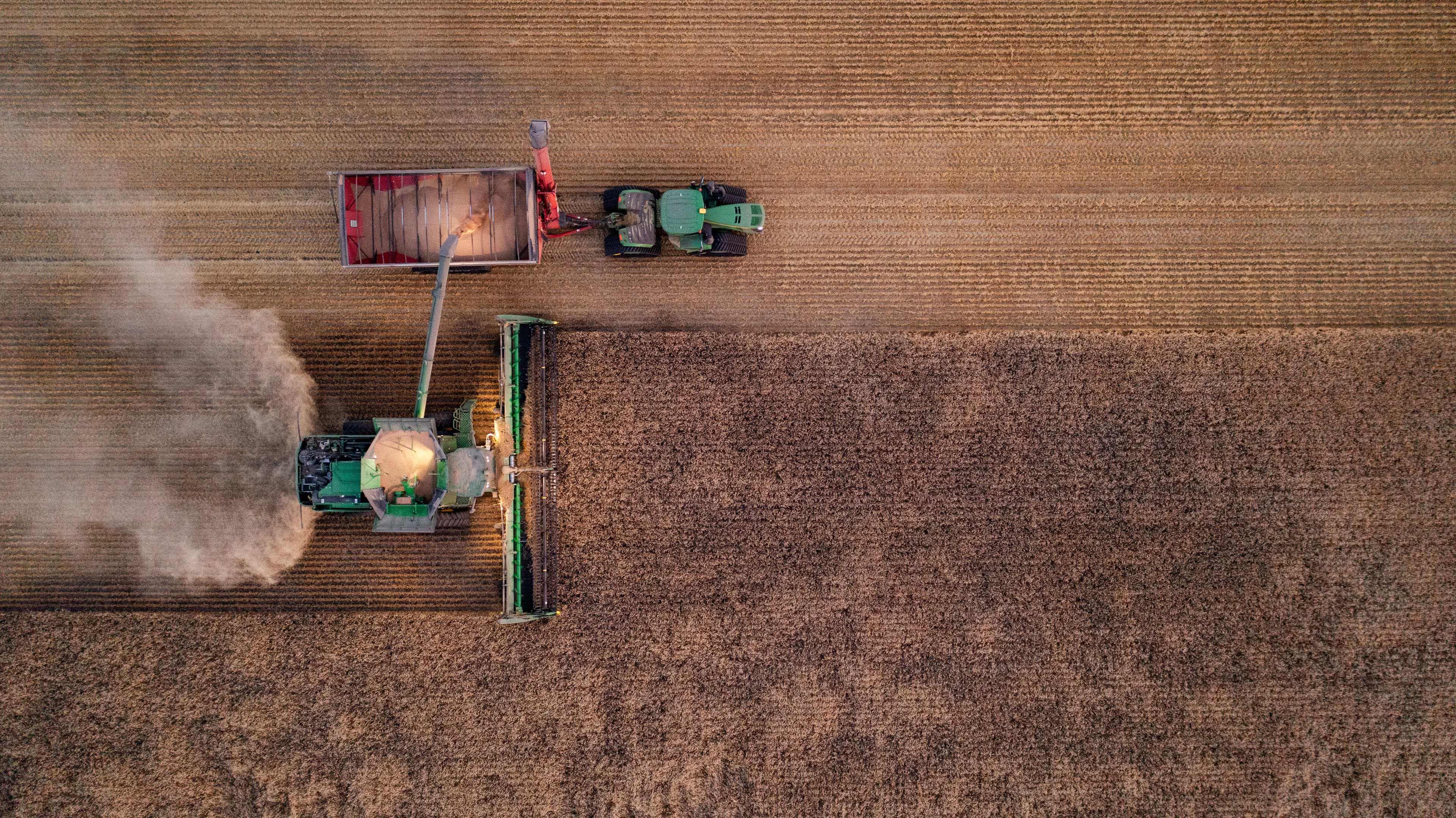 Farmers harvesting crops in Canadian agricultural fields